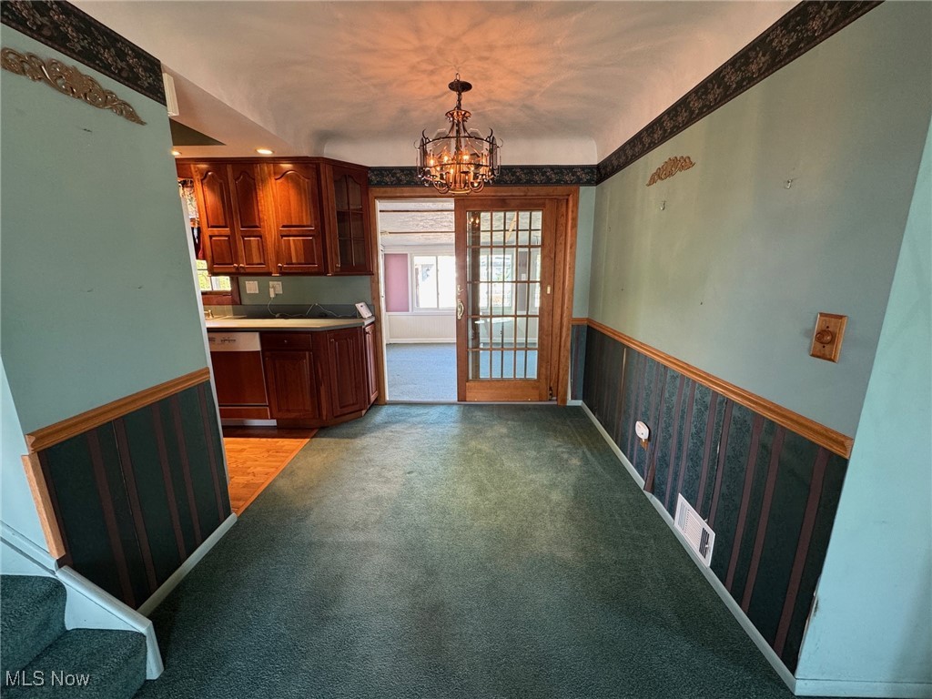 725 Pendley Road Willowick, OH 44095 - Photo 6 of 36 Dining area featuring a wainscoted wall, carpet, and a chandelier