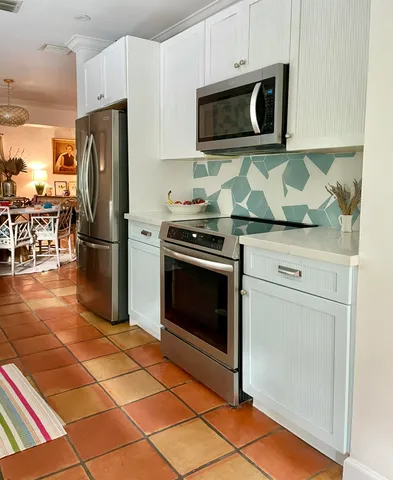 a kitchen with granite countertop a stove and a microwave