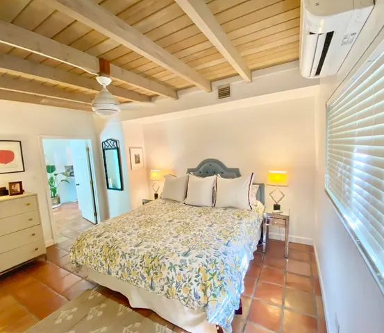 a bed sitting in a bedroom next to a window