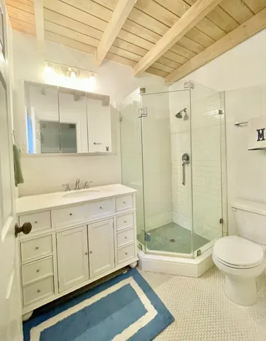 a bathroom with a granite countertop sink a toilet and shower