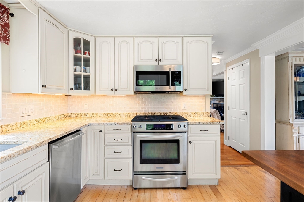 35 Spallus Road Stoughton, MA 02072 - Photo 21 of 39 a kitchen with stainless steel appliances granite countertop a stove a microwave and a refrigerator