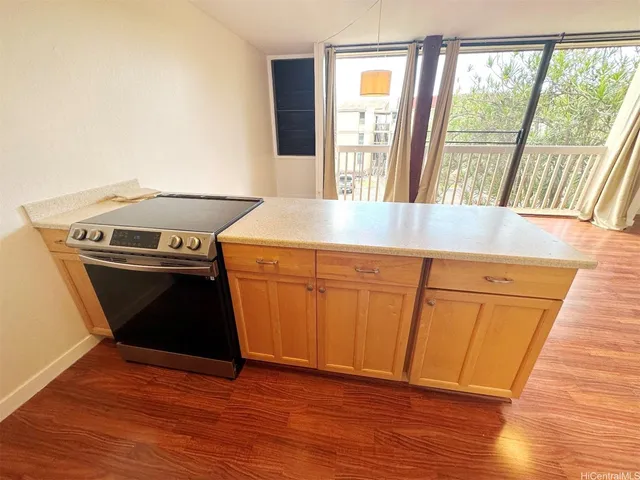 a kitchen with a refrigerator a stove cabinets and wooden floor