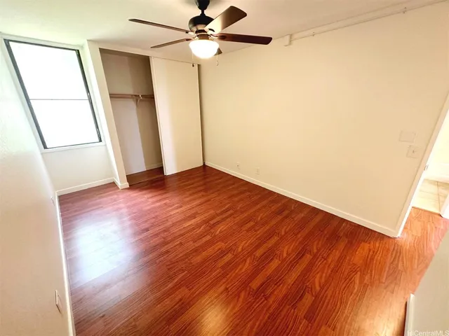 a view of an empty room with wooden floor