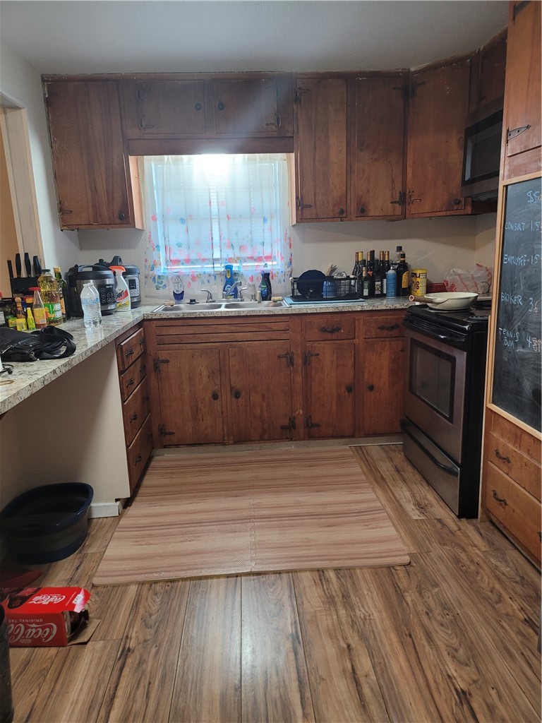 125 Harbor Circle Mathis, TX 78368 - Photo 5 of 12 a kitchen with wooden floors and wooden cabinets