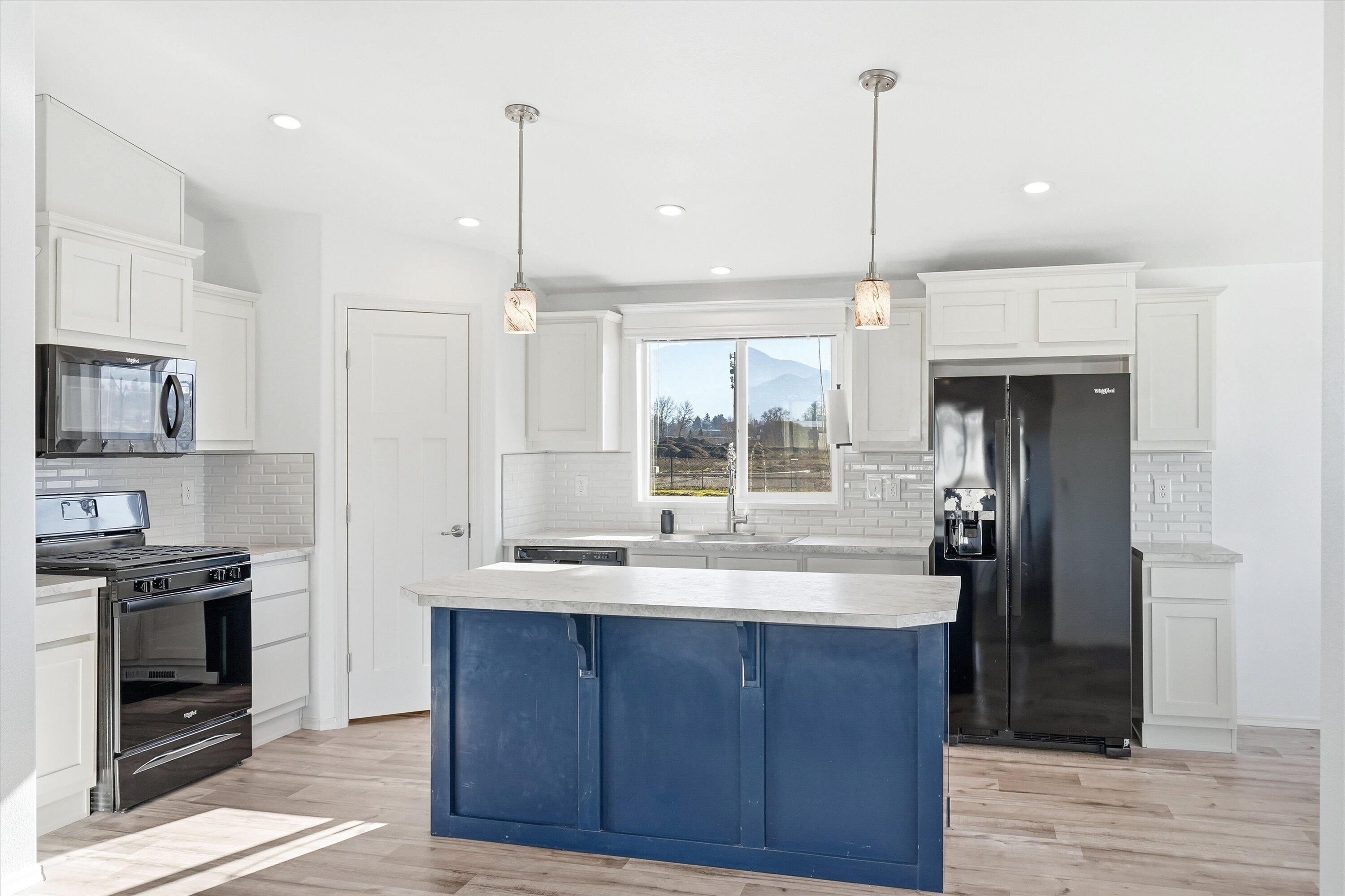300 Luman Road, Unit 197 Phoenix, OR 97535 - Photo 6 of 26 a kitchen with kitchen island granite countertop stainless steel appliances and wooden cabinets