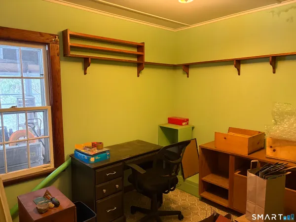 a view of a workspace with furniture and a window