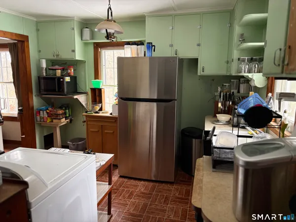 a kitchen with a refrigerator a stove top oven a sink and a dining table