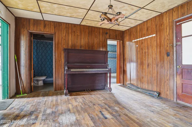 a view of room with hardwood floor and a ceiling fan
