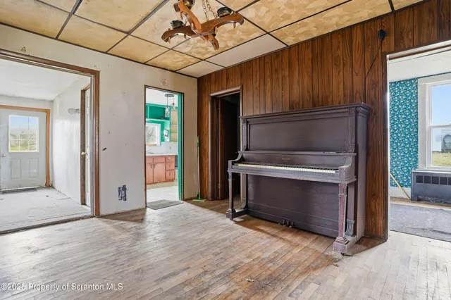 a view of an empty room with wooden floor fireplace and a window