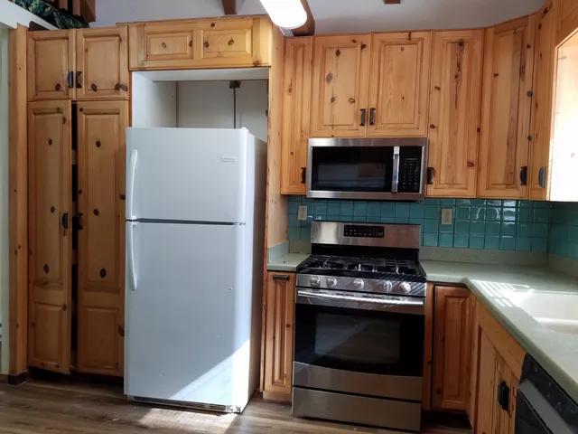 a kitchen with stainless steel appliances granite countertop a sink and wooden cabinets