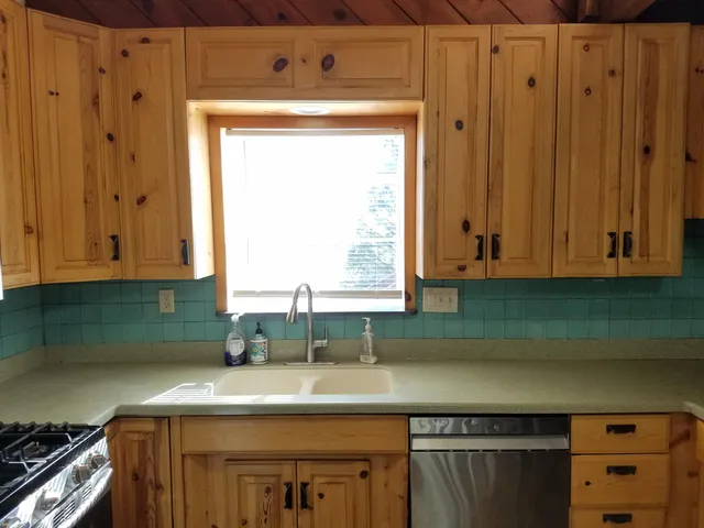 a kitchen with a refrigerator and a stove top oven