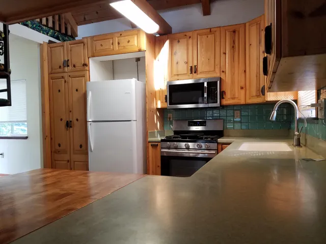 a kitchen with granite countertop a refrigerator and a stove top oven