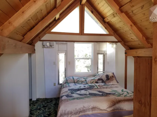 a bed sitting in a bedroom next to a window