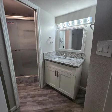 a bathroom with a granite countertop sink and a mirror