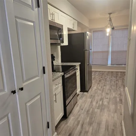 a kitchen with granite countertop a refrigerator and a sink