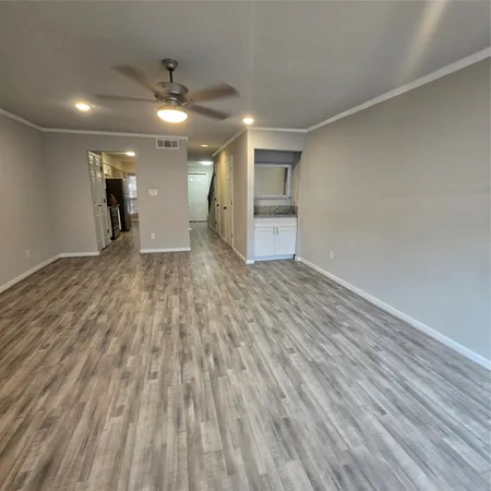 a view of empty room with wooden floor