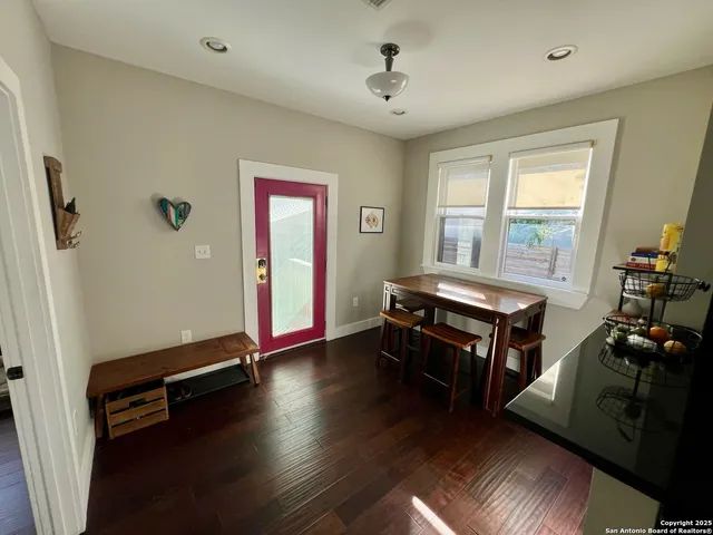 a room with furniture pool table wooden floor and windows