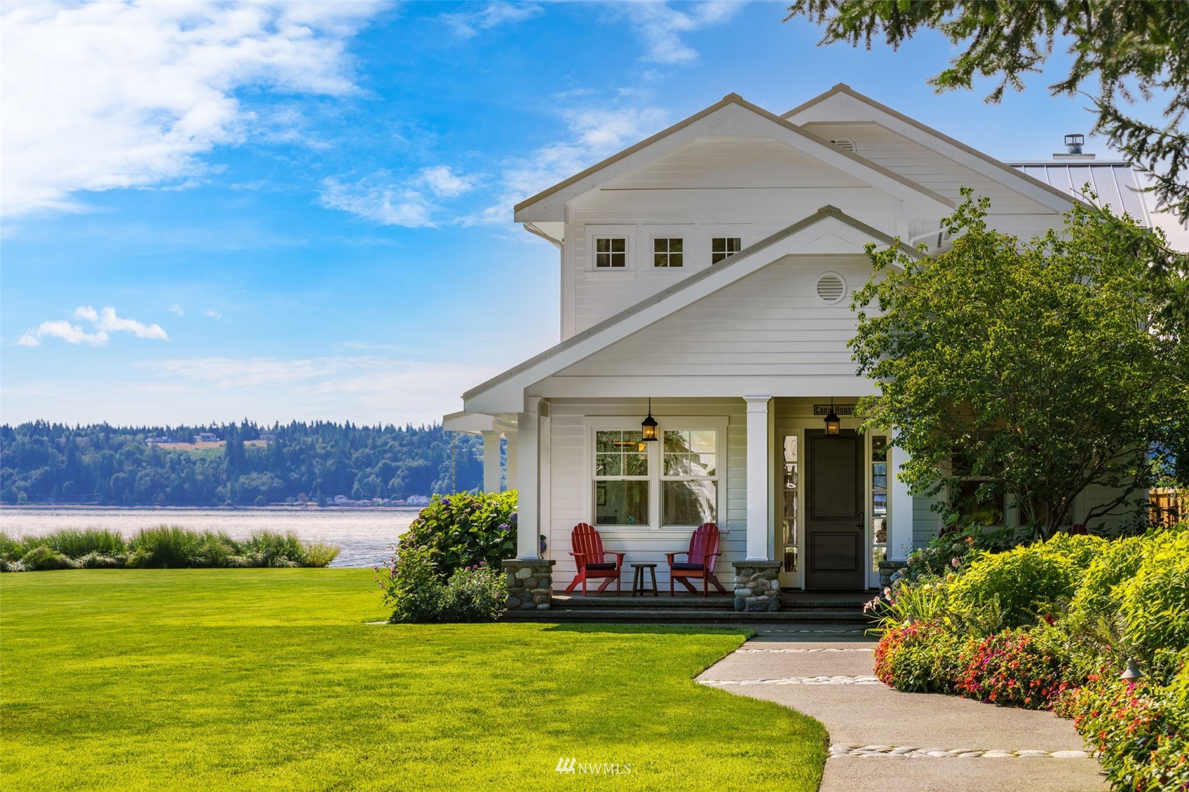 6797 Northeast North Shore Road Belfair, WA 98528 - Photo 2 of 40 a view of a white house with a big yard and potted plants