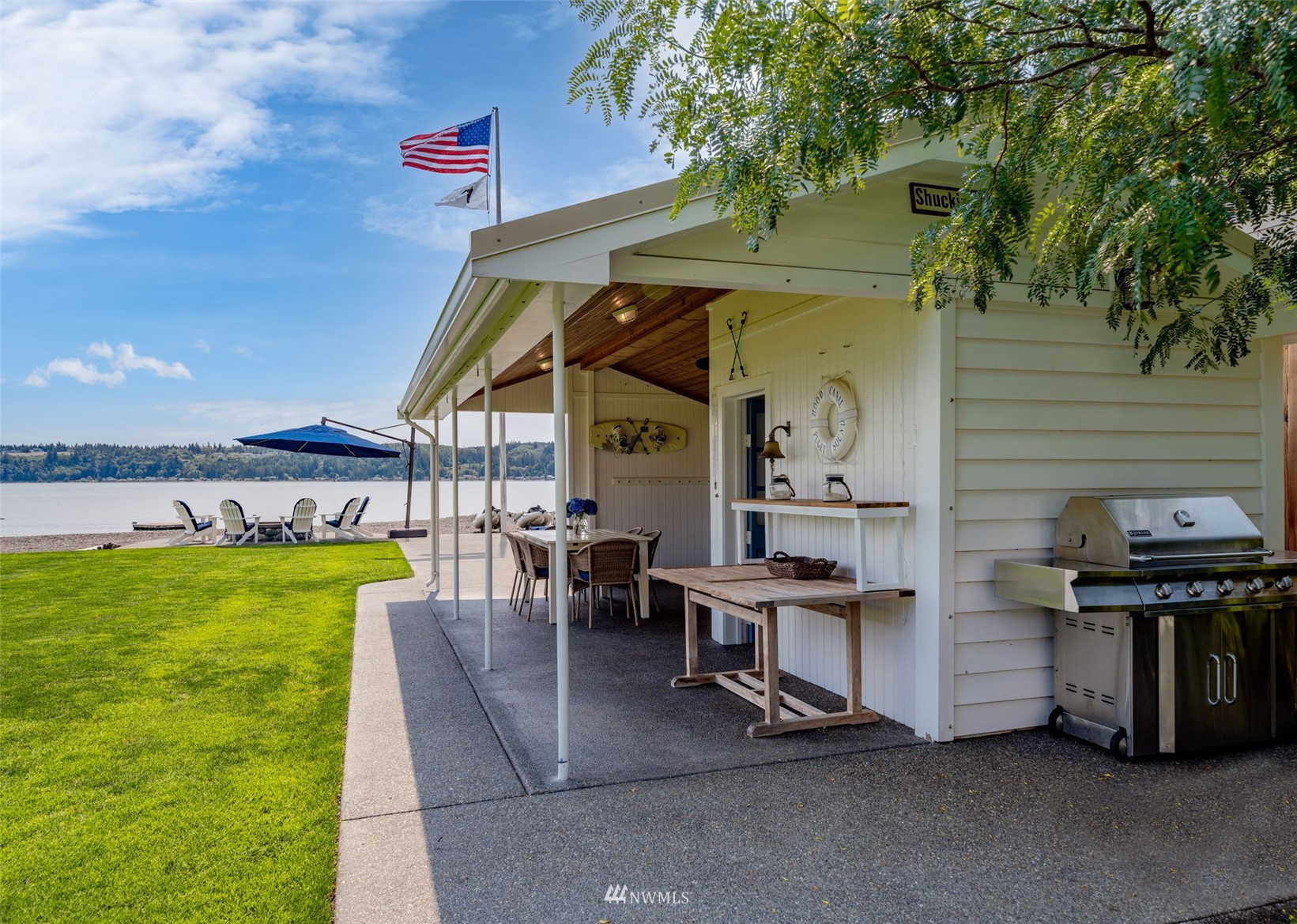 6797 Northeast North Shore Road Belfair, WA 98528 - Photo 22 of 40 a view of a patio with table and chairs a barbeque