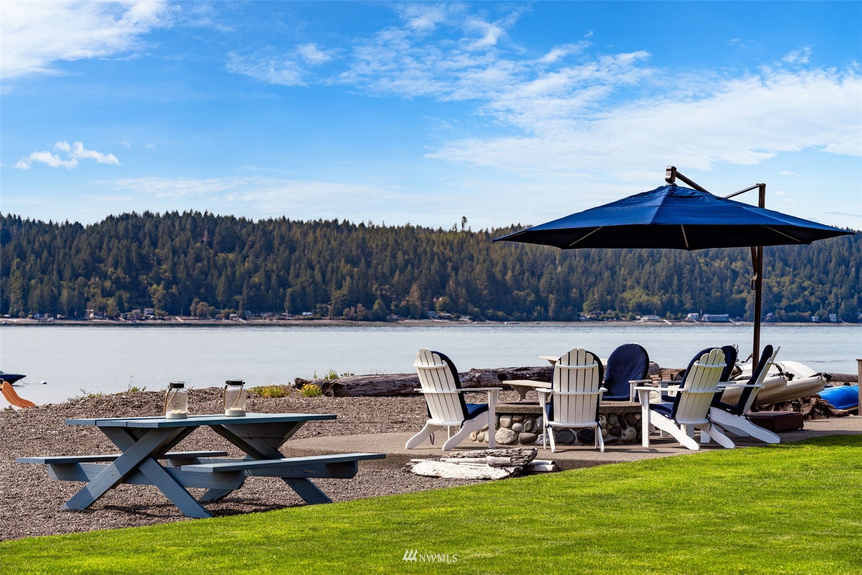6797 Northeast North Shore Road Belfair, WA 98528 - Photo 34 of 40 a view of a swimming pool with lawn chairs and a fire pit
