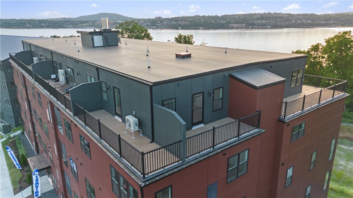 View of property with a water view and central air condition unit