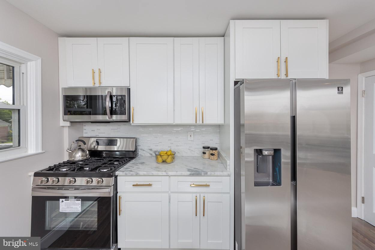 5923 Falkirk Road Baltimore, MD 21239 - Photo 14 of 27 a kitchen with stainless steel appliances granite countertop a refrigerator a stove a microwave and cabinets