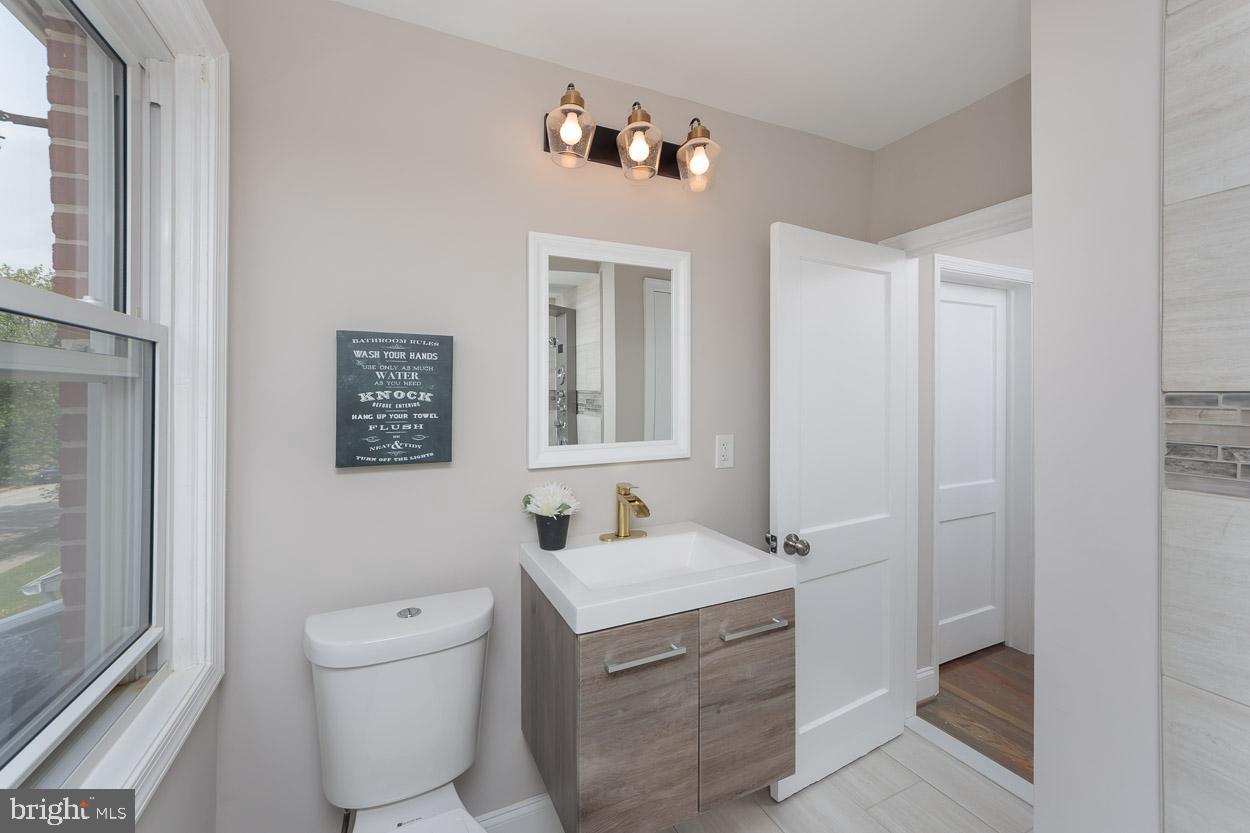 5923 Falkirk Road Baltimore, MD 21239 - Photo 22 of 27 a bathroom with a sink toilet and mirror