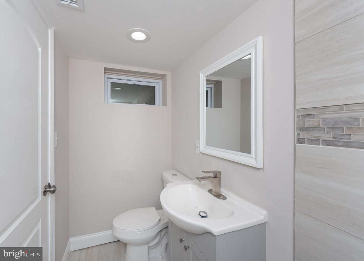5923 Falkirk Road Baltimore, MD 21239 - Photo 26 of 27 a bathroom with a toilet sink and mirror