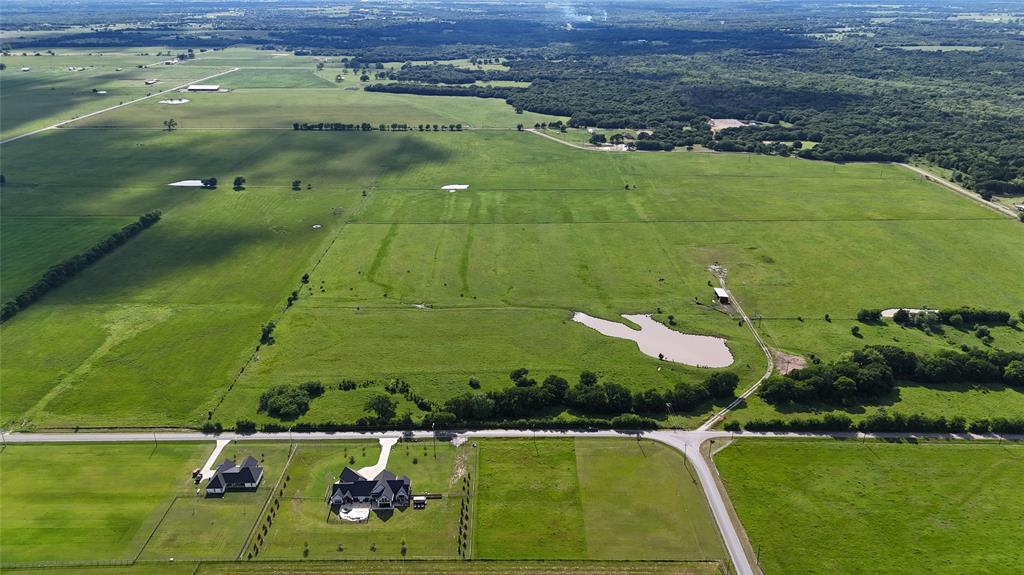 Tbd-10 R Tbd-10 R Brooks Lane Sadler, TX 76264 - Photo 14 of 16 Expansive green pastures featuring a private pond, scattered trees, and distant wooded areas