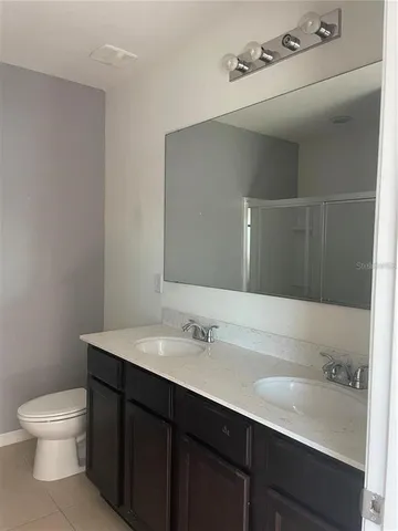 a bathroom with a sink a toilet and a mirror
