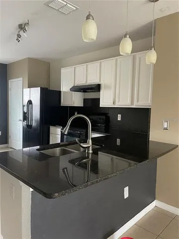 a kitchen with kitchen island a sink stainless steel appliances and cabinets