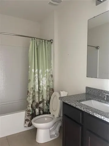 a bathroom with a granite countertop sink a toilet and a bathtub