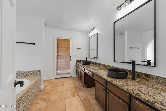 a bathroom with a granite countertop bathtub shower and a sink