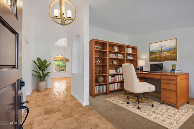 an empty room with mirror and fan