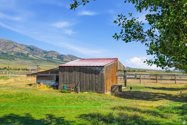 1634 West Arimo Road Arimo, ID 83214 - Photo 52 of 89 Rustic barn with red metal roof, weathered wood siding, and adjacent fenced pastures
