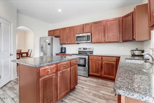 a kitchen with stainless steel appliances granite countertop a stove refrigerator sink and cabinets