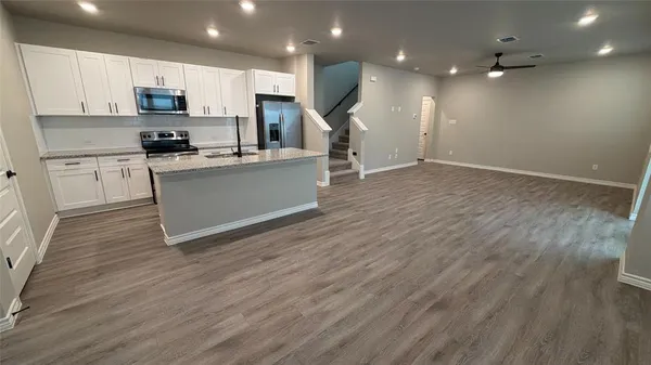 a kitchen with stainless steel appliances granite countertop a stove a sink and a microwave