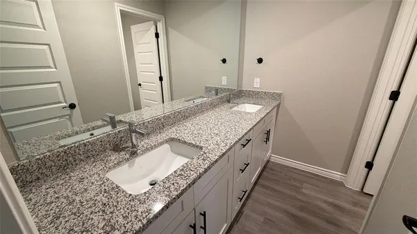 a bathroom with a granite countertop sink and a mirror