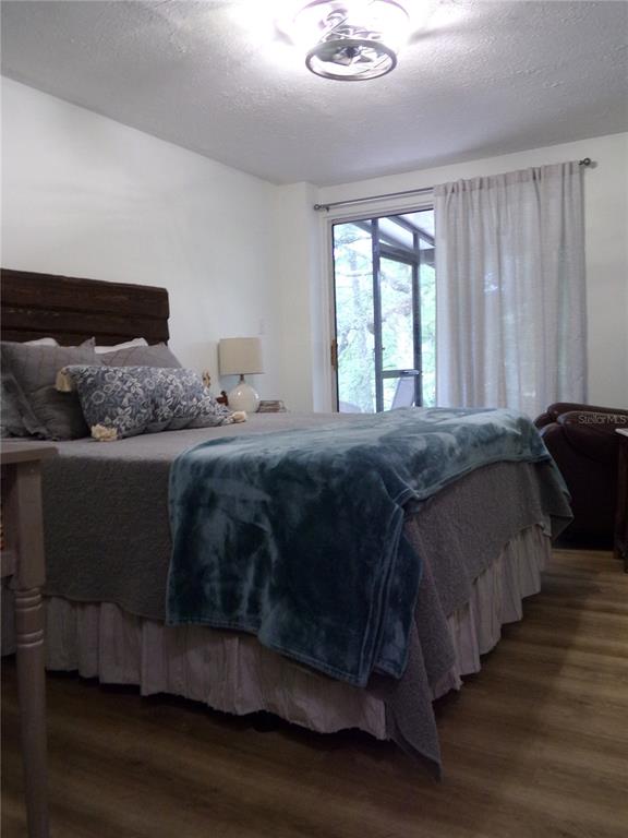 33068 Round Table Road Dade City, FL 33523 - Photo 34 of 82 a bedroom with a bed and wooden floor