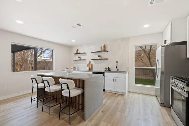 a kitchen with a table chairs refrigerator and microwave