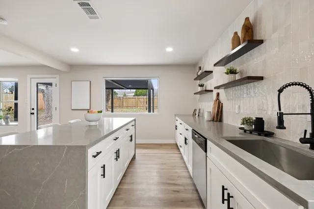 a large kitchen with stainless steel appliances granite countertop a lot of counter space and wooden floors