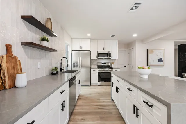 a kitchen with stainless steel appliances a sink stove and refrigerator