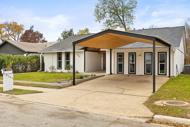 a view of white house with a yard and potted plants