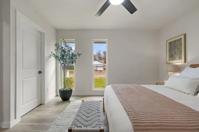a bedroom with a bed and a potted plant