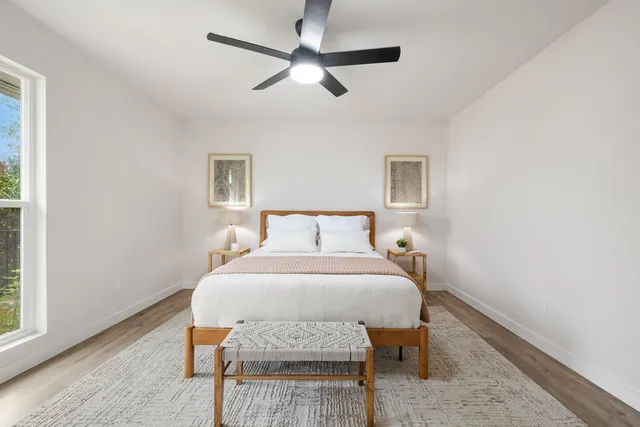 a bedroom with a bed a window and lamps