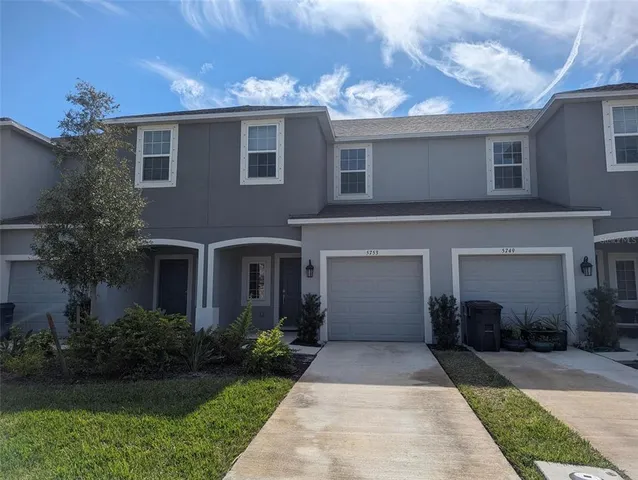 a front view of a house with a yard and a garage