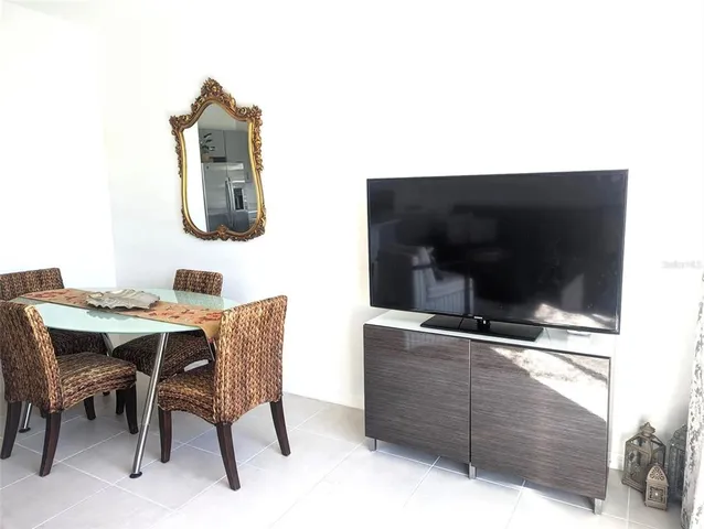 a room with a table chairs and a flat screen tv