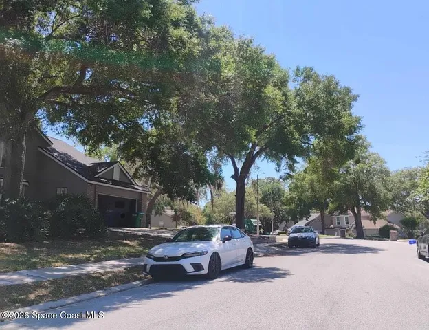 a view of a patio with couches and a fire pit and a large tree
