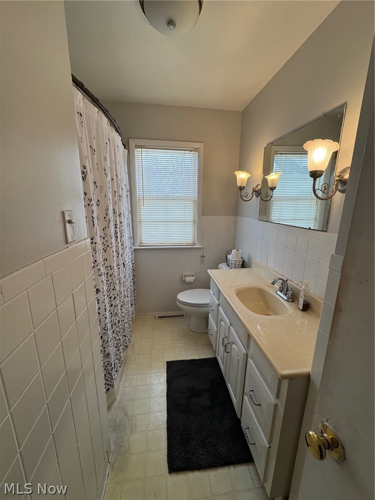 3828 Lake Road West Ashtabula, OH 44004 - Photo 29 of 29 Full bath featuring tile walls, wainscoting, vanity, and a shower with curtain