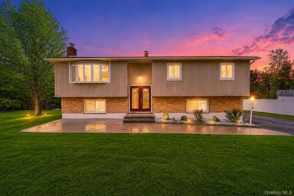 a front view of a house with patio and a yard